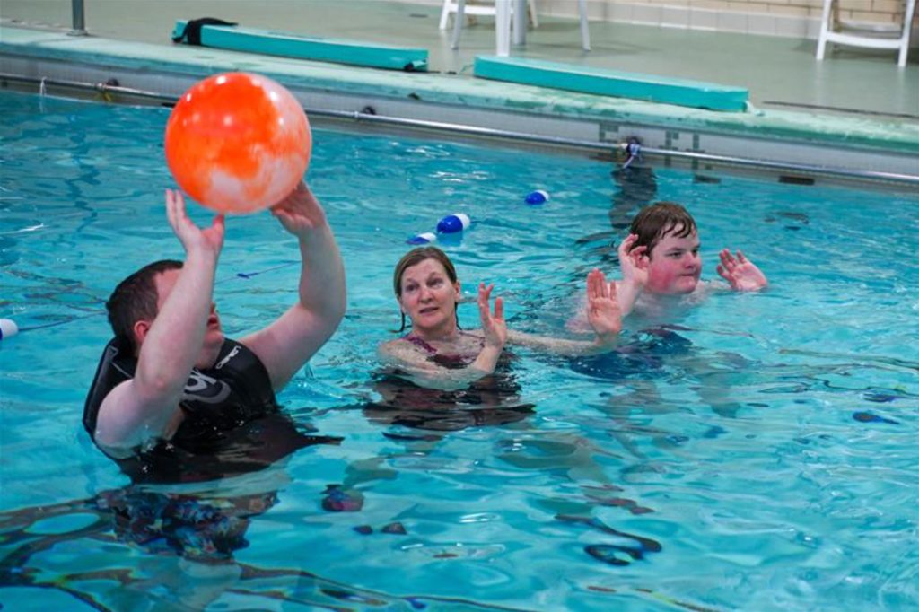 physical therapy aquatics instructor instructs students in the pool