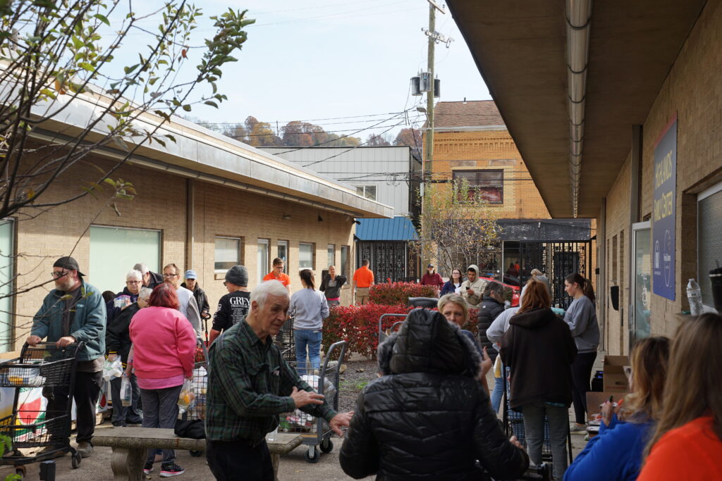 People with shopping carts receiving food donations.